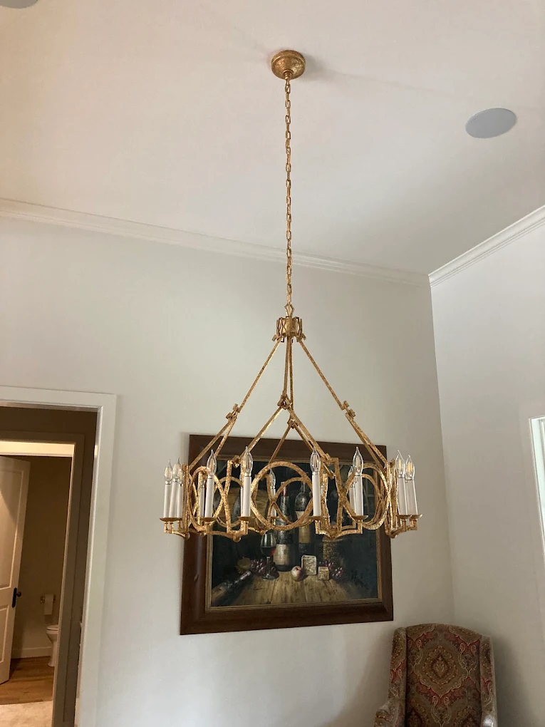 Gold candle-style chandelier hung and wired in a Montgomery County home hallway
