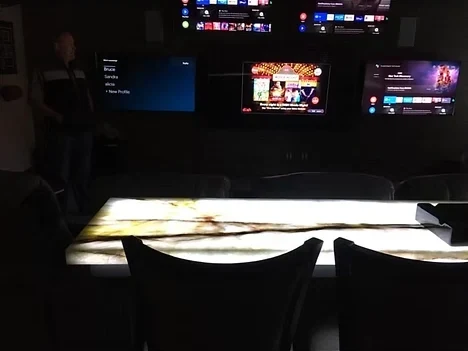 Media room with wall-mounted televisions and lit bar countertop wiring