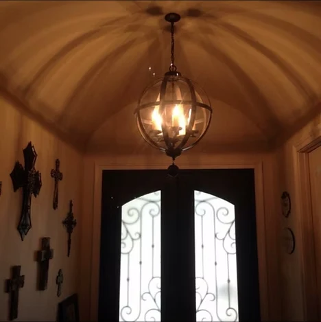 Entry foyer with a barrel ceiling and globe chandelier installed by Lowe Home Electric