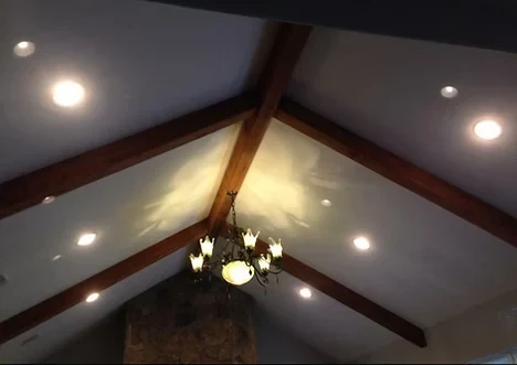 Great room with exposed beams, recessed lights and a chandelier on a vaulted ceiling